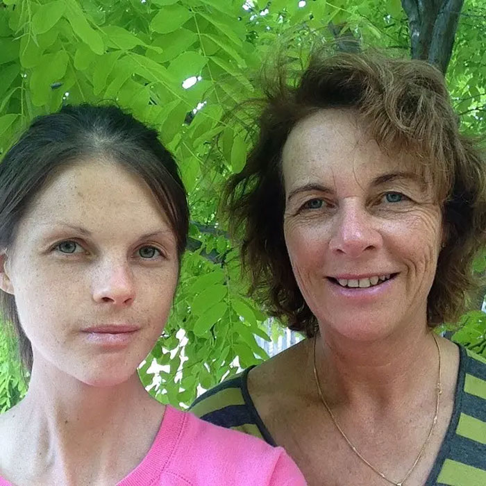 Australian woman and another person outdoors under green leaves, related to excessive caffeine consumption risks.