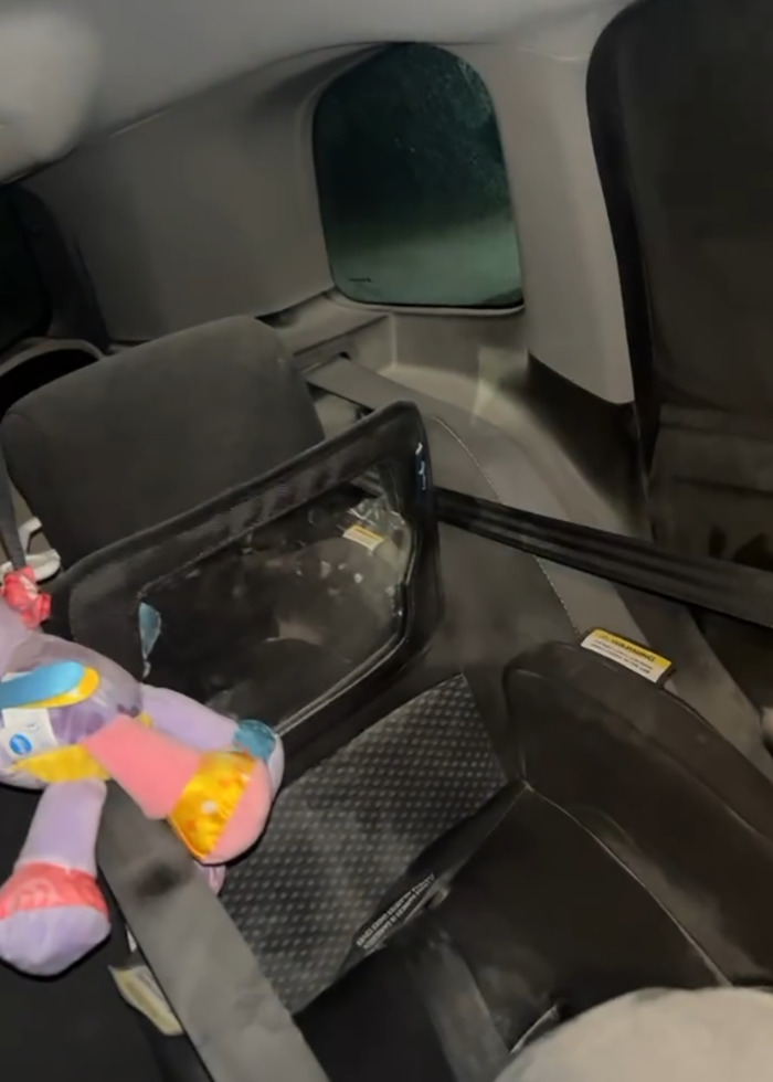 Car seat in back of car with baby toy and child safety barrier after fire extinguisher prank incident involving 5-month-old baby.
