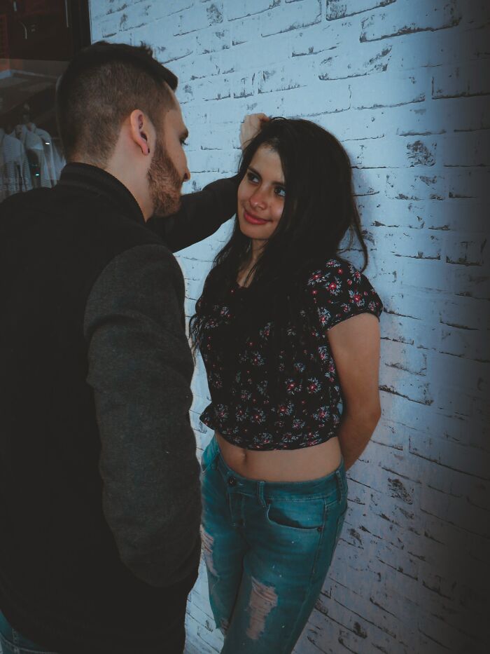 Young man and woman standing close against a wall, hinting at tension after hooking up with a friend’s parent.