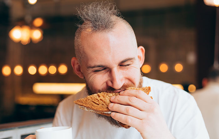 Man with mohawk enjoying a spicy lunch in a cafe, highlighting a coworker steals woman’s spicy lunch story. Man with mohawk enjoying a spicy lunch in a cafe, highlighting a coworker steals woman’s spicy lunch story.