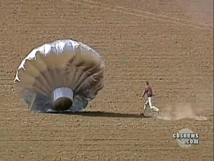 Person running toward deflated balloon on open field related to Balloon Boy family controversy years later.
