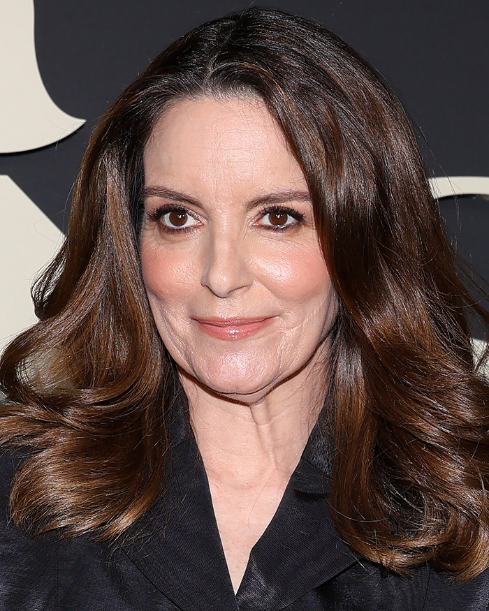 Close-up of a female celebrity with visible body abnormalities, featuring natural skin texture and brown hair styled in loose waves.