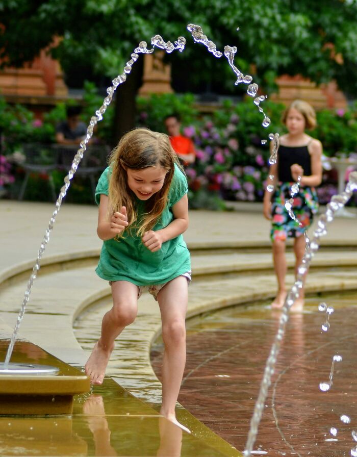Young children playing near water fountains outdoors, illustrating challenges some worst parents have faced with their kids.