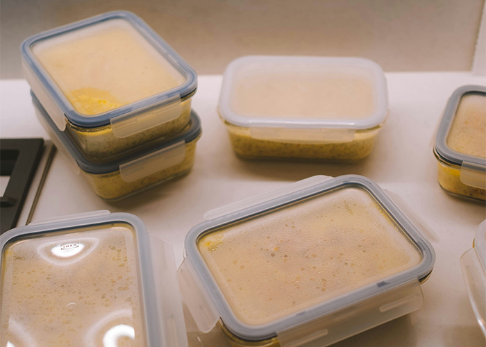 Stacked and organized meal prep containers on a kitchen counter illustrating habits to improve quality of life.