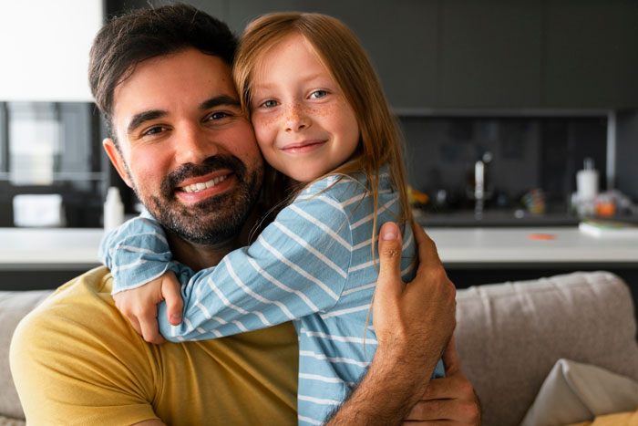 Smiling father hugging daughter in a cozy home, reflecting on relationship doubts despite an 8-year affair controversy.