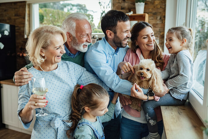 Happy multi-generation family with children and dog enjoying time together at home, showcasing cultural differences that shock Americans