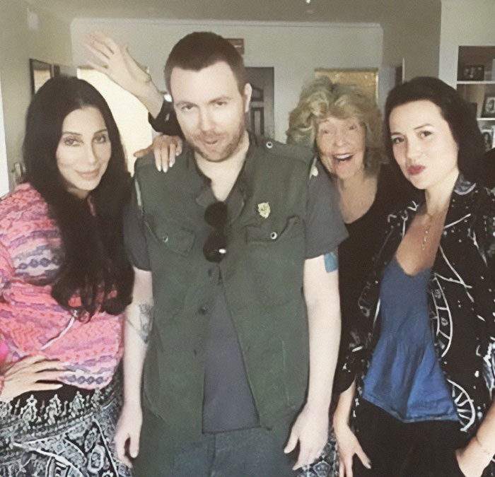 Cher with family members, standing indoors, highlighting challenges amid son's near-fatal overdose and alleged kidnap attempt.