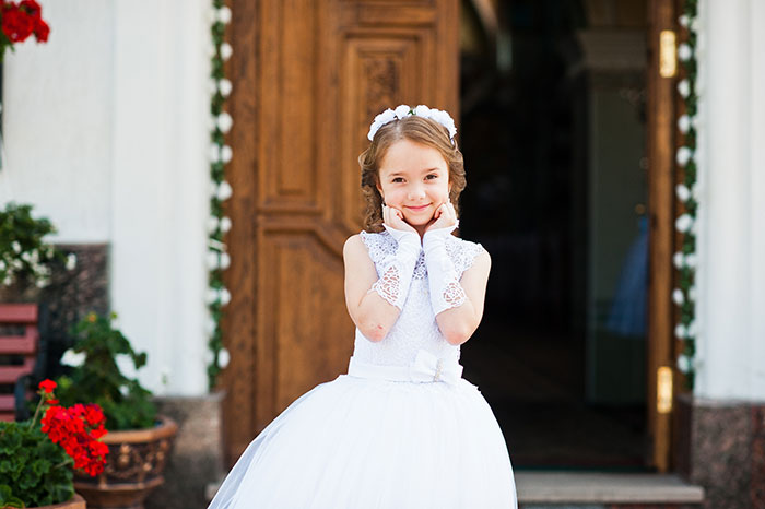 Young girl in white dress posing outside doorway, related to Disneyland wedding interrupted by staff keyword.