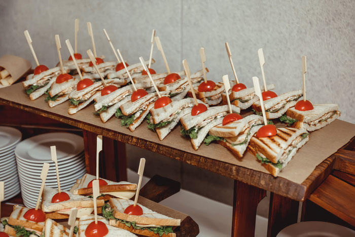 Tray of sandwiches garnished with cherry tomatoes, representing a man saving $100 on dinner with coupon. Tray of sandwiches garnished with cherry tomatoes, representing a man saving $100 on dinner with coupon.