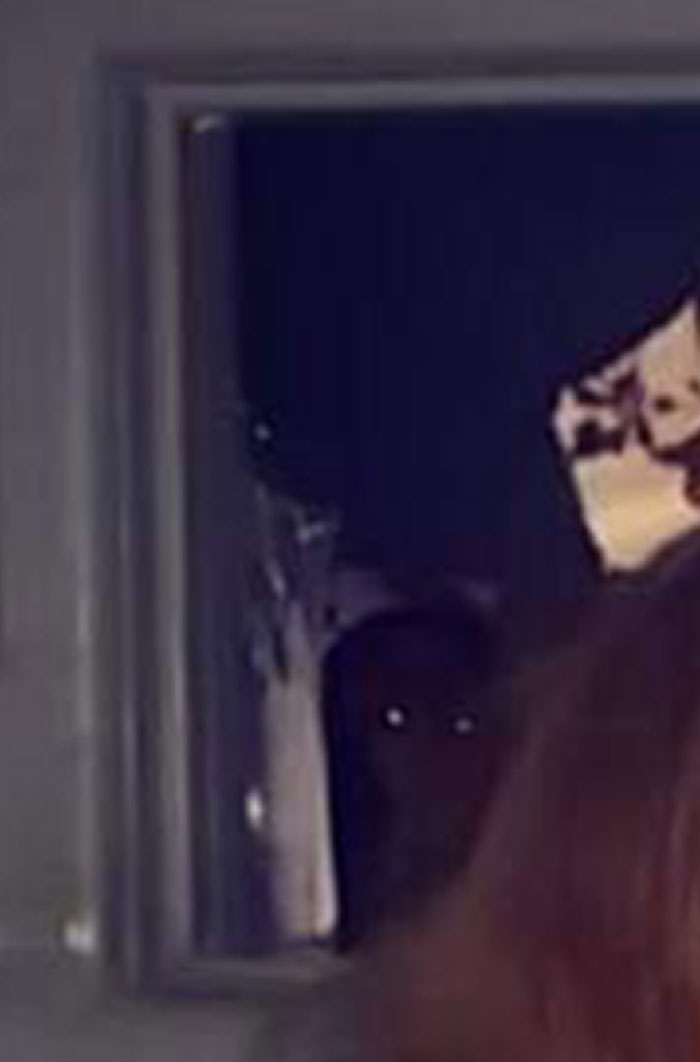 Shadowy figure with glowing eyes in a dark mirror reflection, depicting a chilling ghost encounter at night.