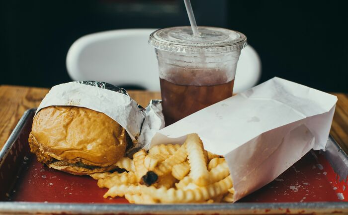 Fast food meal with burger, crinkle fries, and iced drink illustrating casual habits that may be damaging in the long run.