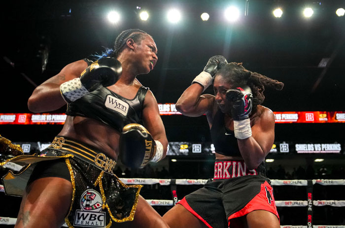 Claressa Shields delivering a powerful punch in a boxing match, showcasing her boxing champ skills and strength.