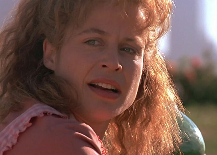 Close-up of a former Hollywood star outdoors with sunlight highlighting her hair, reflecting on life after leaving the spotlight.