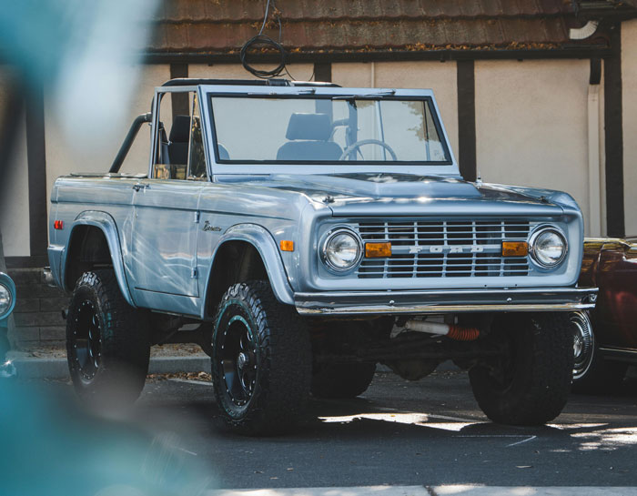 Vintage 1972 Ford Bronco parked outdoors, showcasing classic design and rugged off-road tires in natural light.