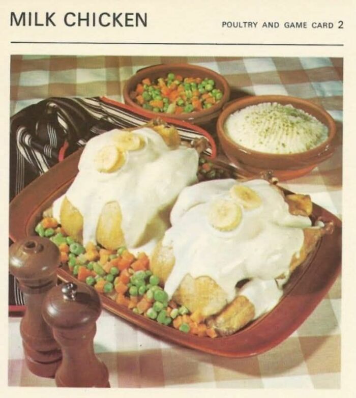 Milk chicken covered in white sauce with banana slices, served with mixed vegetables and mashed potatoes, a gross food example.