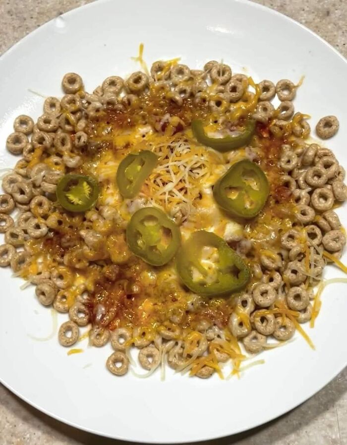Cereal with melted cheese and jalapenos on a white plate, an unusual dish from gross foods that might lose your appetite.