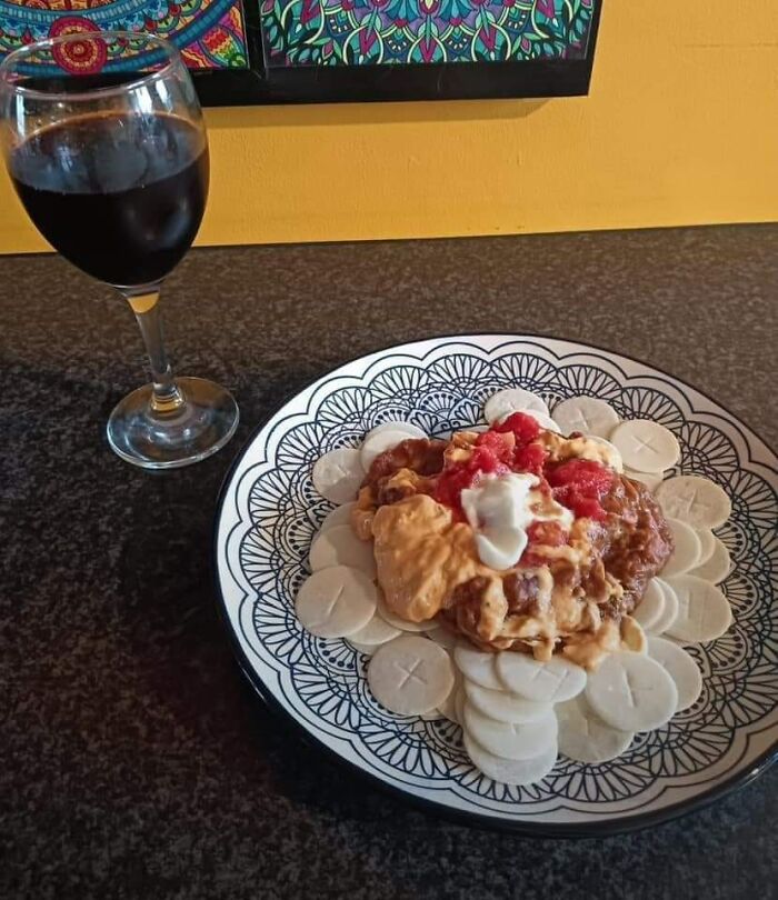 Plate with an unusual dish of sauces and sliced white rounds beside a glass of dark liquid, illustrating gross foods concept.