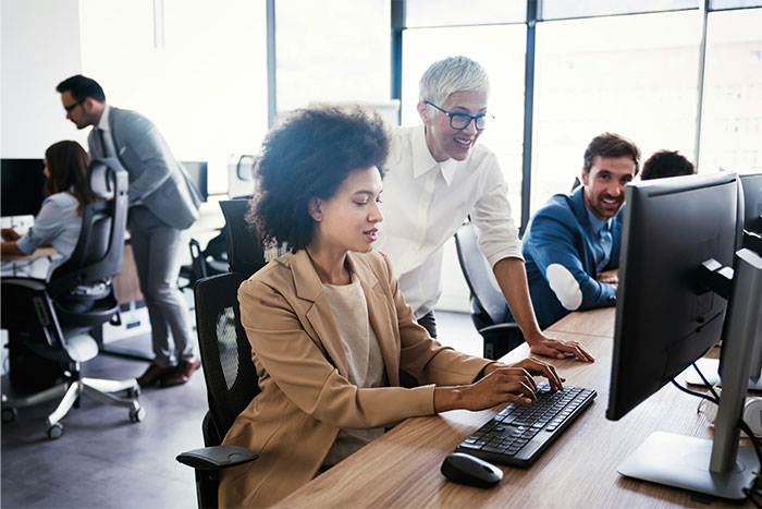 A diverse group of professionals collaborating in an office, illustrating what cool kids who peaked in high school are doing now.