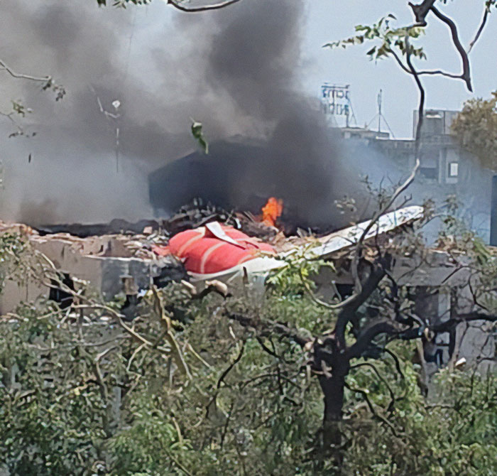 Smoke and flames rise from wreckage after Air India plane crashes into medical college campus in a tragic accident.