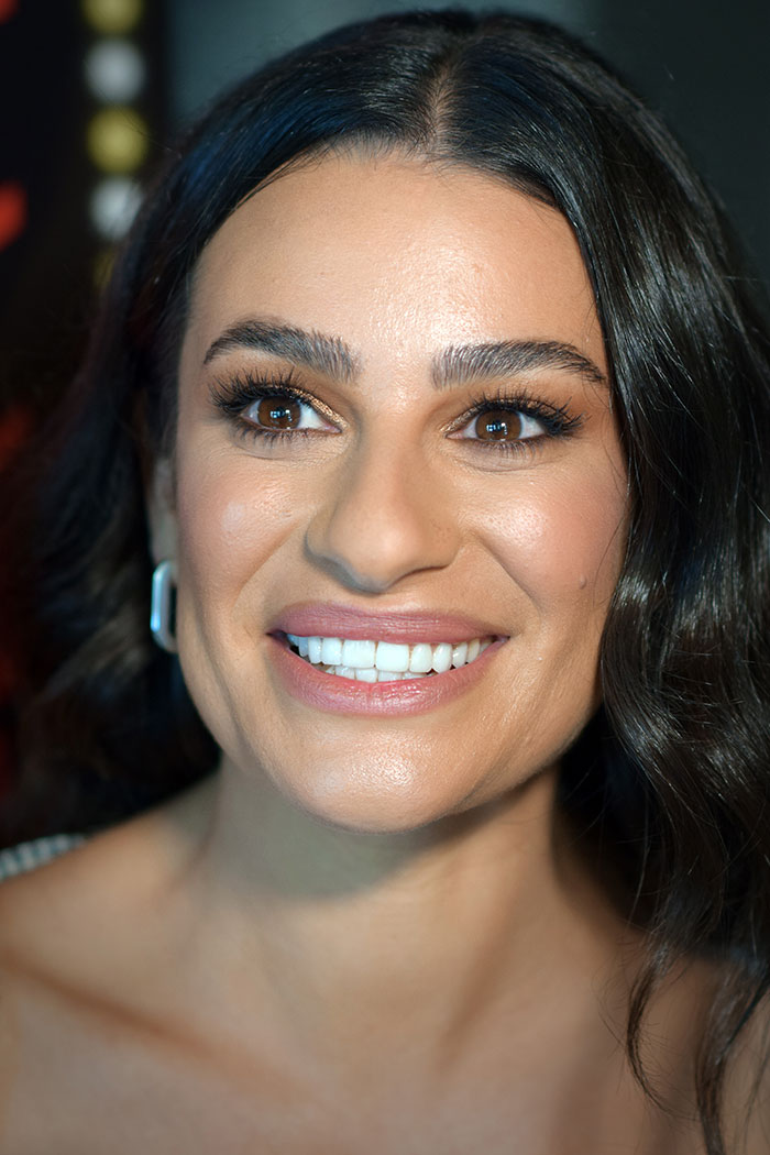 Close-up of a smiling celebrity woman with dark hair in a well-lit setting, highlighting wildest celebrity rumors.