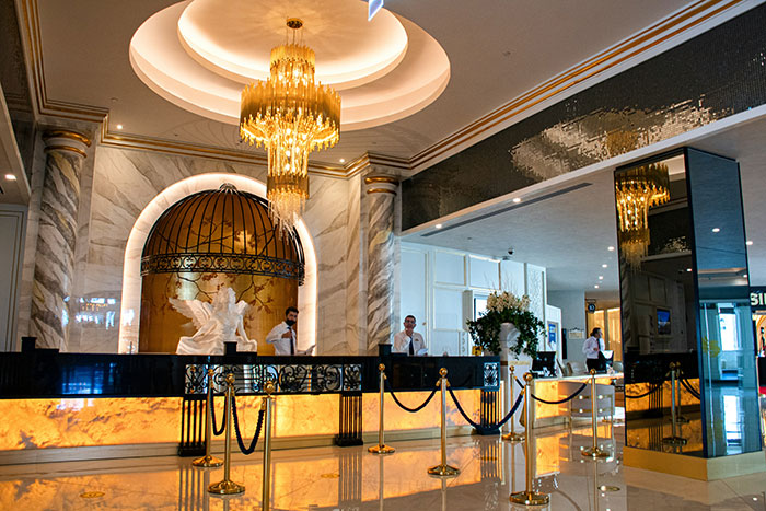 Luxury hotel lobby with ornate chandelier and reception desk, a setting fit for wild celebrity rumors discussions