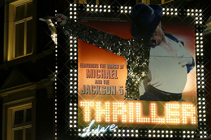 Billboard featuring a Michael Jackson Thriller show, illuminated at night, related to wild celebrity rumors.