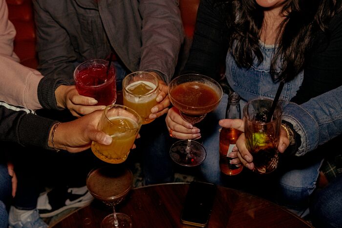 Group of friends holding various drinks, illustrating casual habits that may be damaging in the long run.