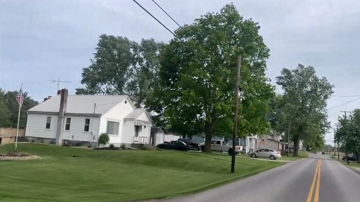 Quiet residential street with houses and trees, one of the creepy and chilling spots in the U.S. that visitors avoid.