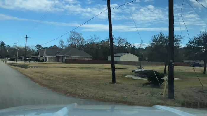 Empty suburban street with utility poles and houses under a partly cloudy sky, one of the creepy and chilling spots in the U.S.