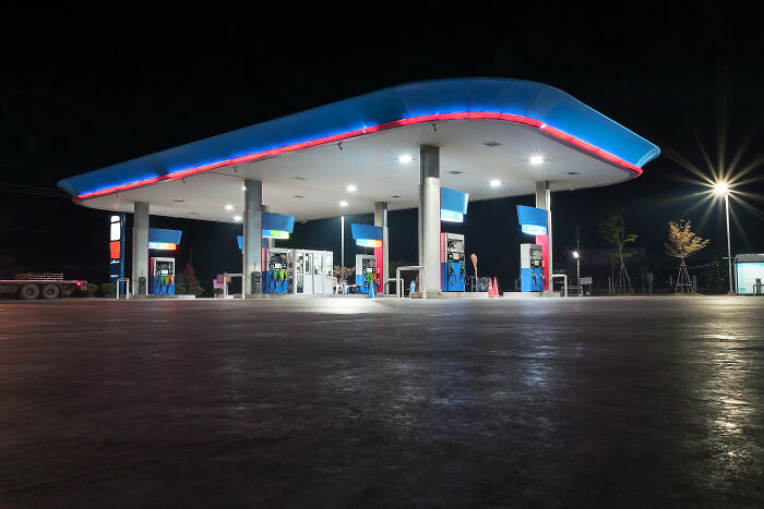 Empty gas station at night with bright lights, one of the creepy and chilling spots in the U.S. noted by visitors.
