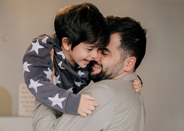 Father and son sharing a close, joyful moment, illustrating emotional challenges of discovering kids aren’t biologically theirs.