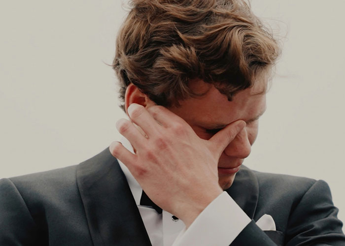 Man in a tuxedo wiping tears from his face, reflecting the emotional pain of discovering kids weren't biologically his.