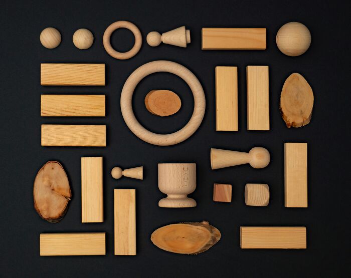 Various wooden shapes and objects arranged on a black background illustrating famous paradoxes and confusion concepts.