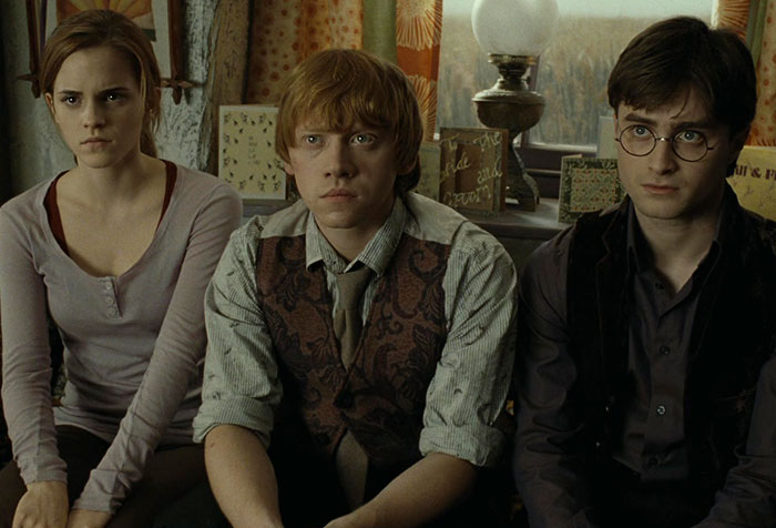 Three Harry Potter actors seated closely, illustrating Tom Felton's controversial red carpet comments enraging fans.
