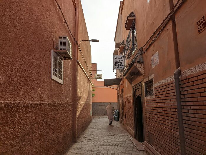 Narrow alleyway in a travel destination with traditional buildings and a person walking, reflecting destinations to avoid for tourists.