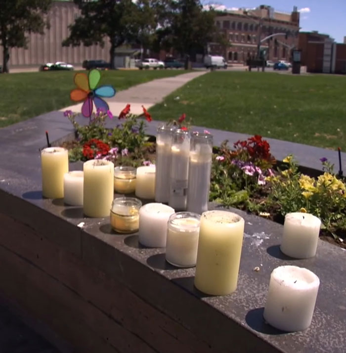 Memorial candles and flowers placed outdoors honoring the bodies of 3 missing sisters found after planned visitation.