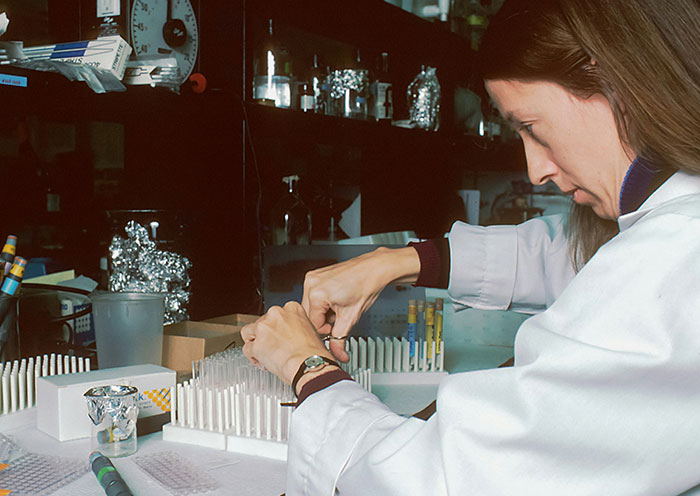 Scientist in a lab conducting DNA tests on samples, related to delivery room stories about paternity and fatherhood.