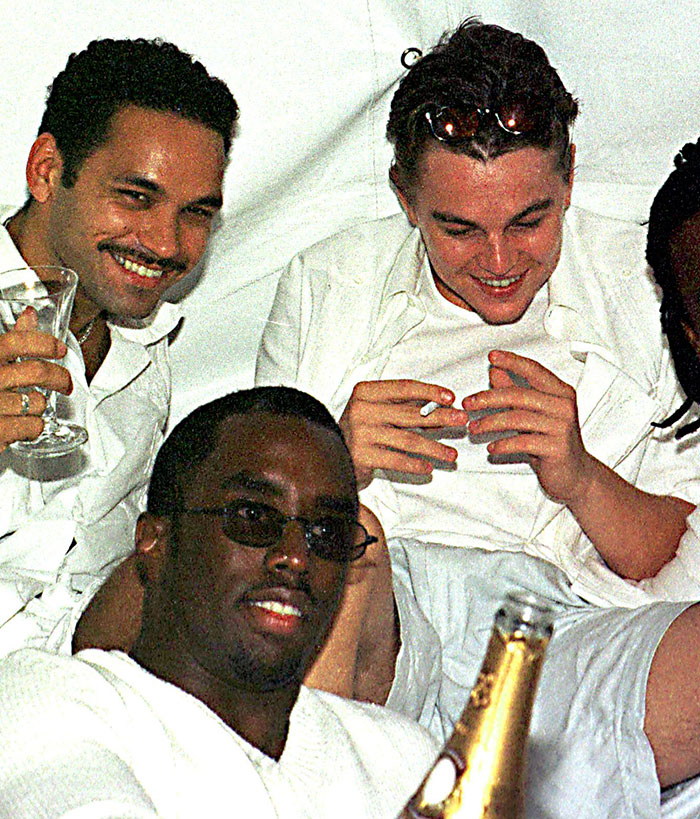 Group of men smiling and socializing at a casual gathering, related to Diddy's trial and celebrity mentions.