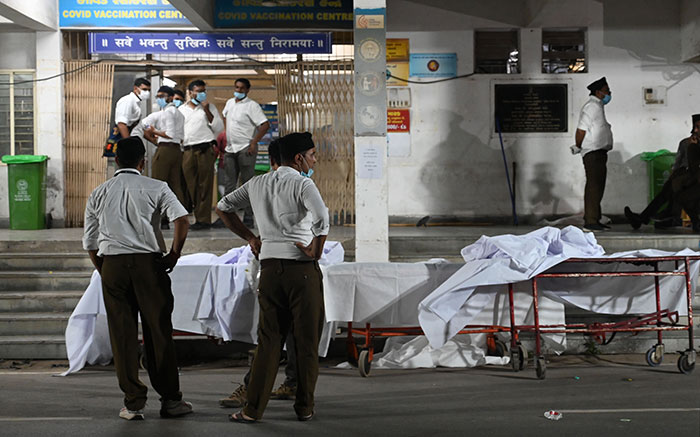Young medical students wearing masks gather outside campus after Air India plane crash incident.