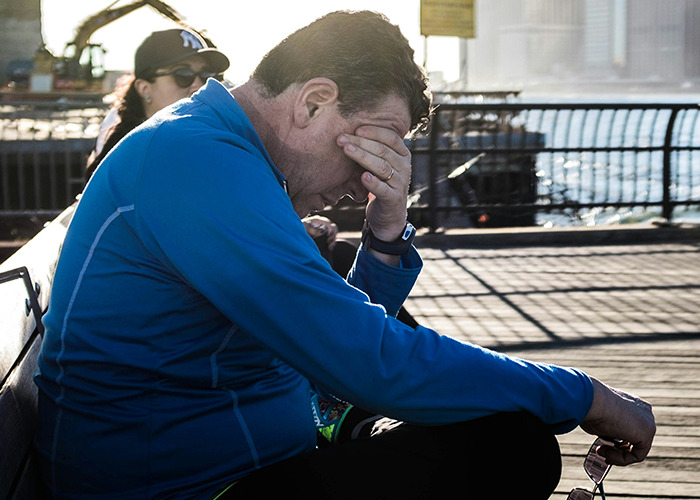 Man in a blue jacket sitting on a bench looking distressed, illustrating medical conditions that surprised doctors