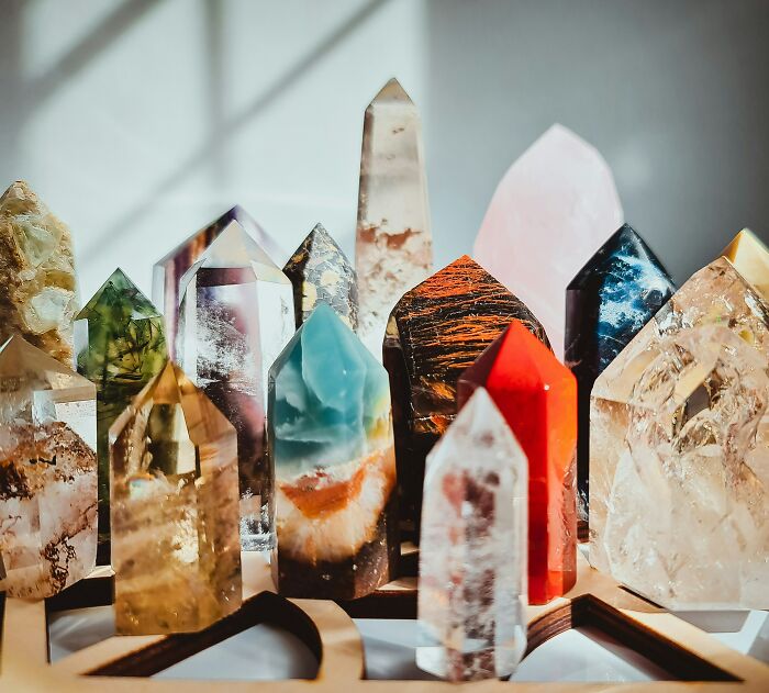 Assorted colorful crystals and stones displayed on a wooden surface, representing popular hobbies that give netizens the ick.