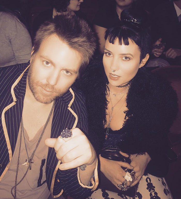 Man and woman sitting together at event, highlighting Cher's family struggles related to son's near-fatal overdose and alleged kidnap attempt.