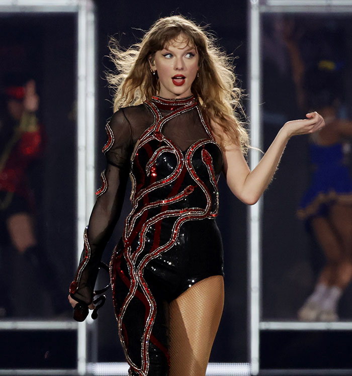 Taylor Swift performing on stage during Eras Tour, criticized for wealth display amid public outing. Taylor Swift performing on stage during Eras Tour, criticized for wealth display amid public outing.