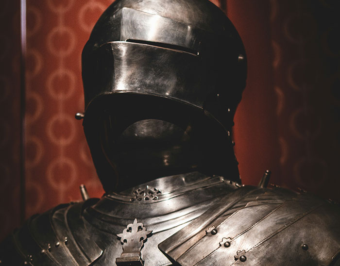 Suit of medieval armor displayed indoors, illustrating common historical knowledge that is actually incorrect.