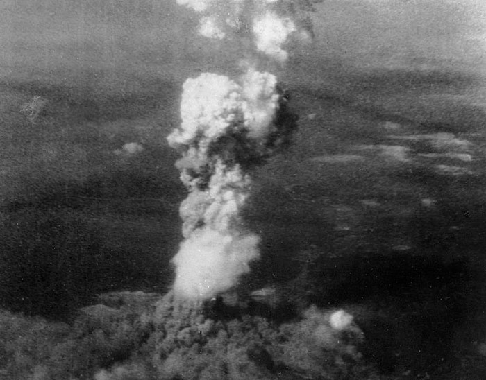 Black and white image of a large mushroom cloud rising from a historical explosion, illustrating common historical knowledge.
