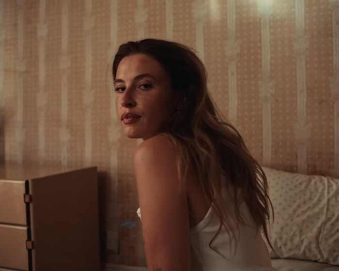 Young woman with long hair sitting indoors, representing famous lesbians who have gotten boyfriends this year trend.