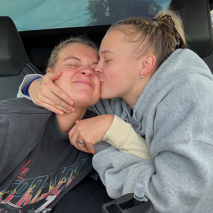 Two women sharing a sweet moment in a car, highlighting the trend of famous lesbians getting boyfriends this year.