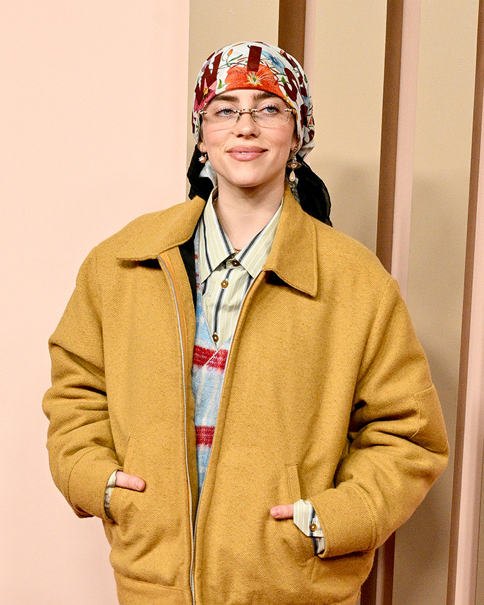 Person wearing a patterned headscarf and tan coat, representing famous lesbians who have gotten boyfriends this year.