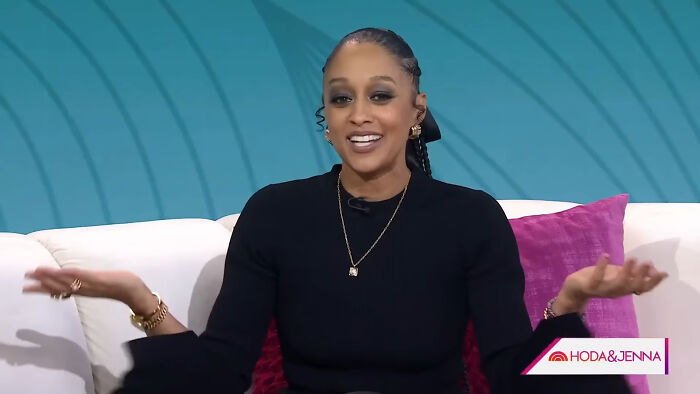 Woman smiling and gesturing during a TV interview discussing Hollywood hypocrisy on aging women and men.