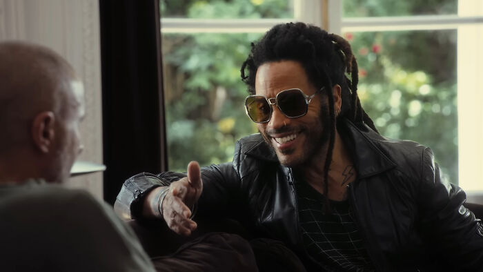Man with sunglasses and dreadlocks smiling and gesturing during a casual conversation highlighting Hollywood hypocrisy and aging.